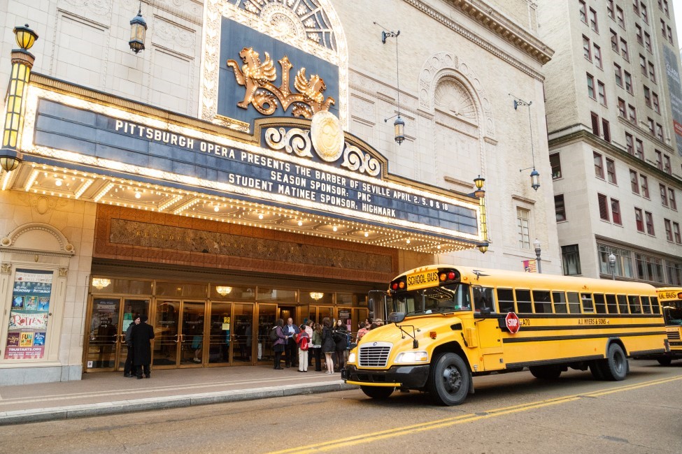 Photo of the exterior of the Benedum Center with a school bus in front of it