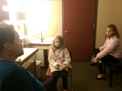 Two young sisters sit and talk to Mark Delavan